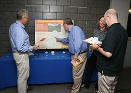 people gathered around pipeline info poster